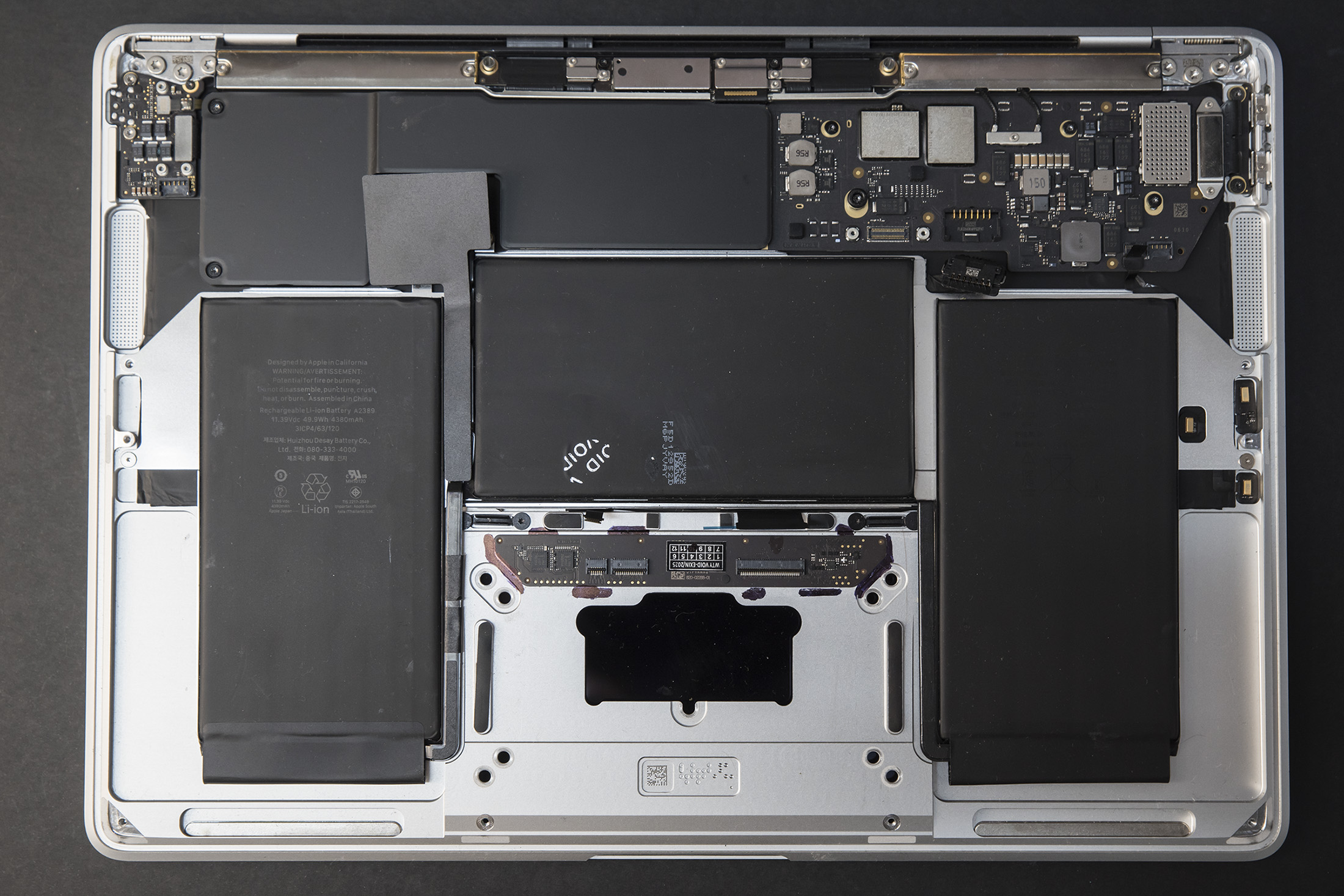 Wnętrze MacBooka Air M1 A2337 po otwarciu – bateria i płyta główna