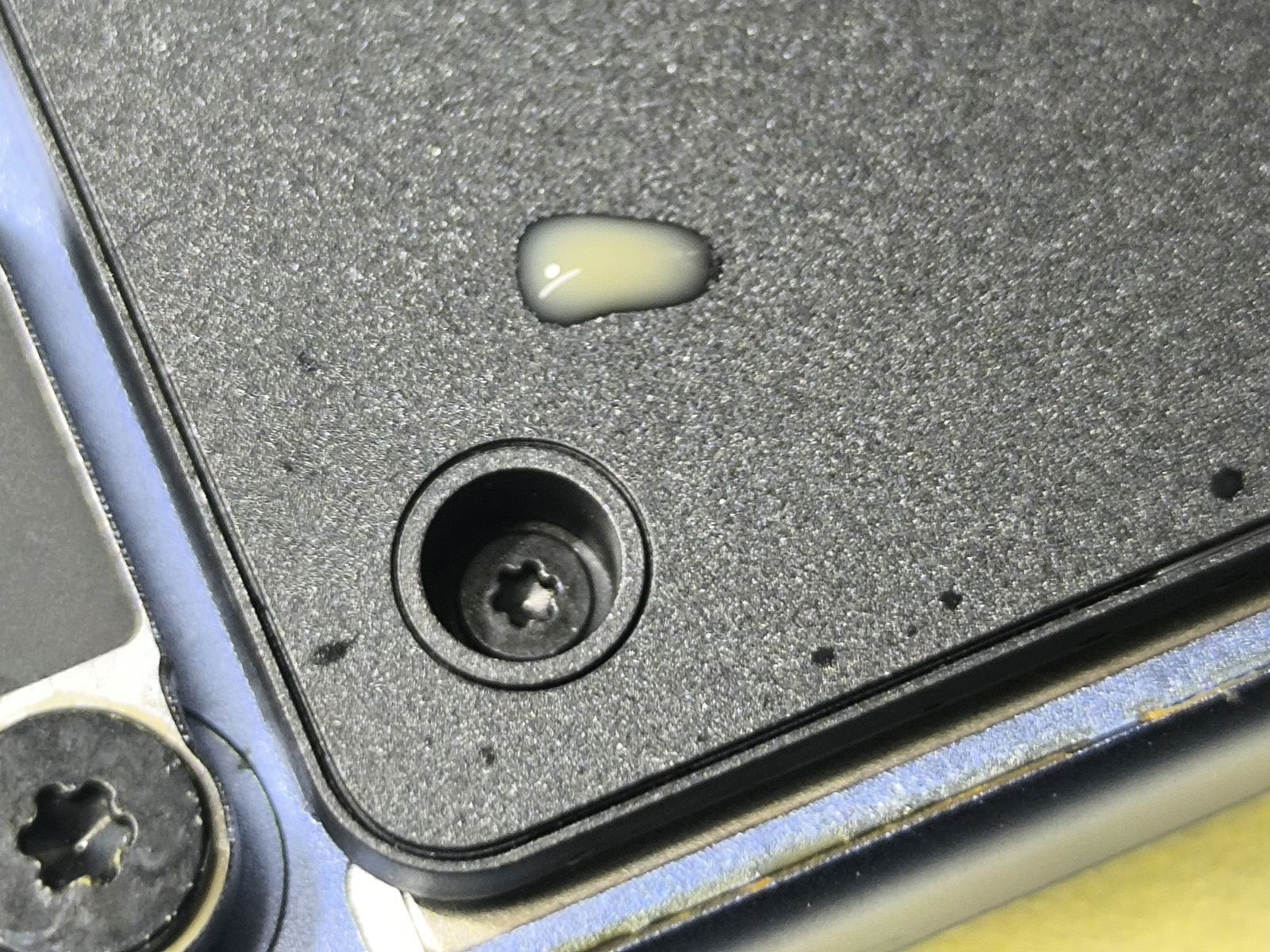 Kawa z mlekiem widoczna wewnątrz zalanego MacBooka po otwarciu obudowy