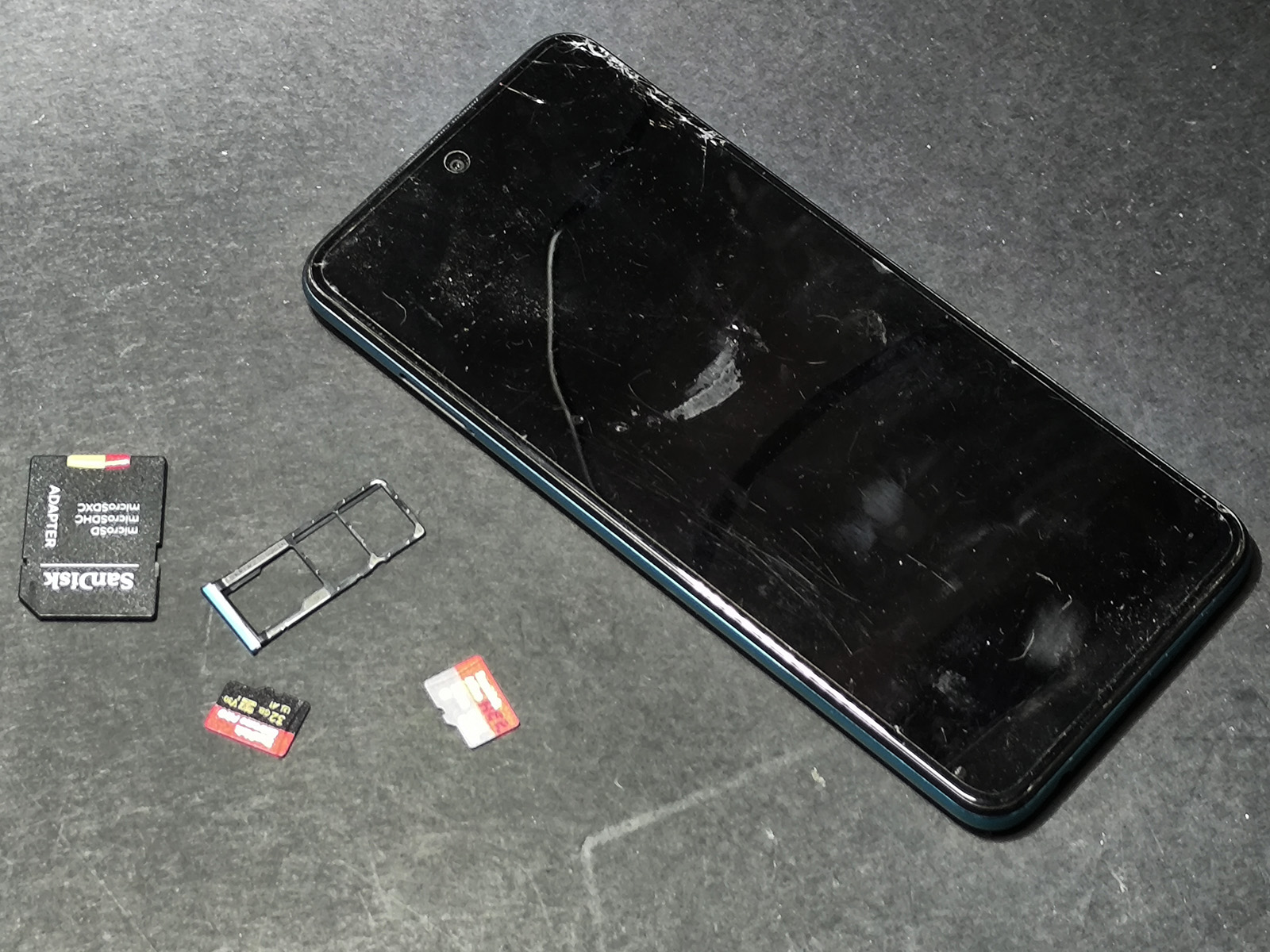 Uszkodzony smartfon i karta microSD przeznaczona do odzyskiwania danych