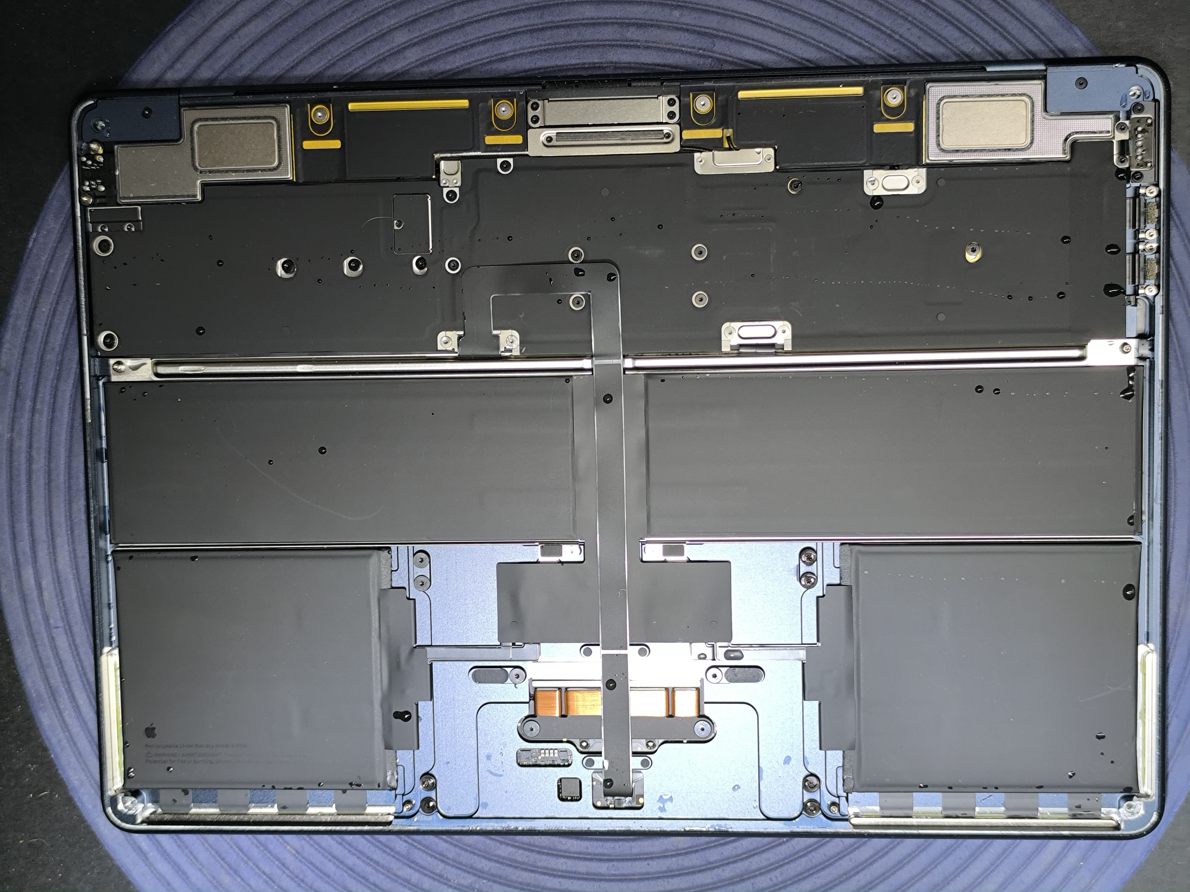 Otwarty MacBook podczas diagnozy i demontażu po zalaniu cieczą